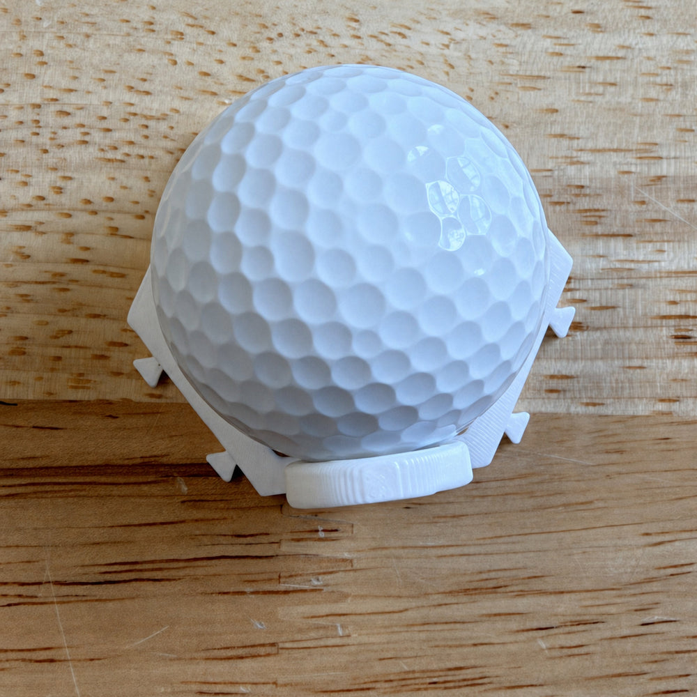 White modular display mount holding a plain white golf ball