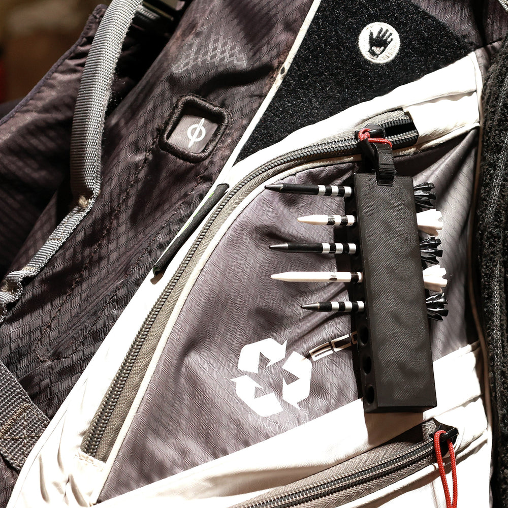 Black golf tee holder loaded with tees on a golf bag