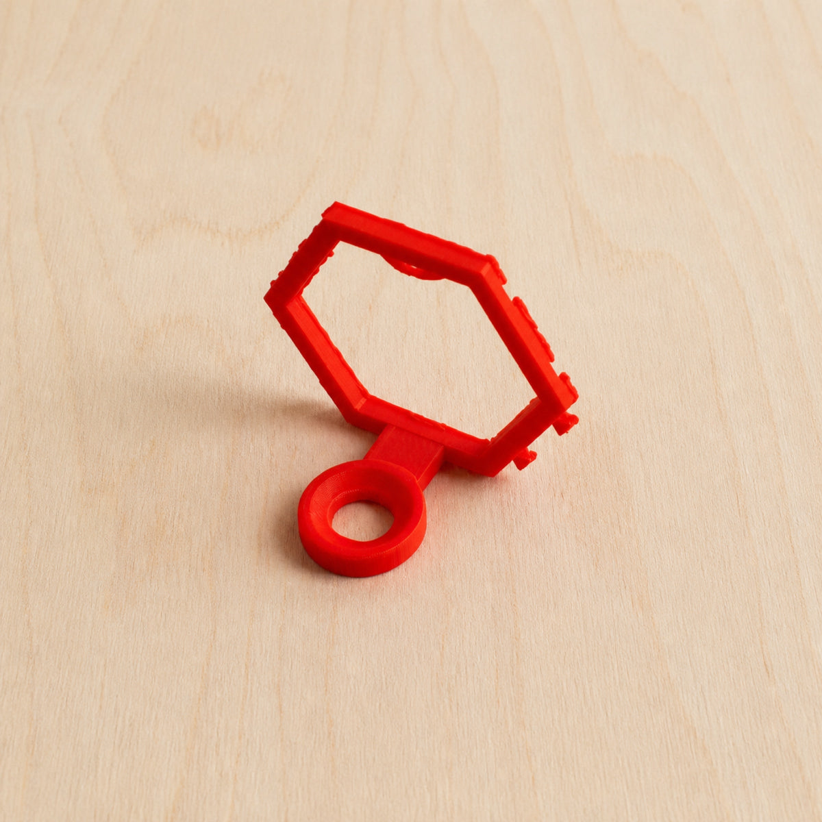 Red modular golf ball display mount on pale wood