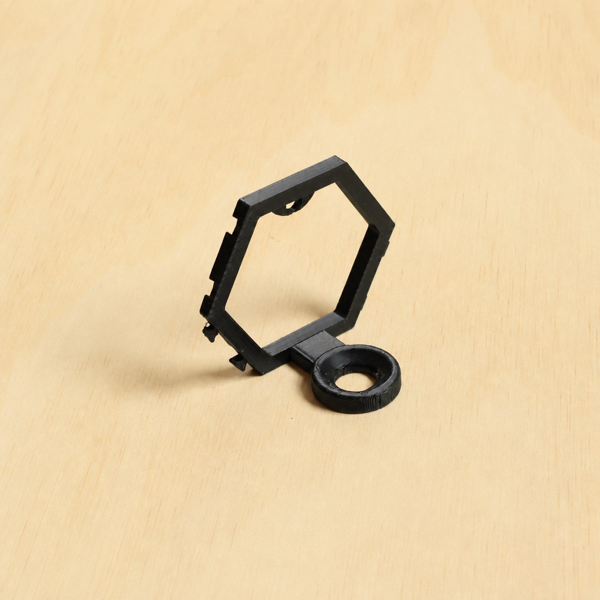Black modular golf ball display mount on pale wood