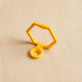 Yellow modular golf ball display mount on pale wood