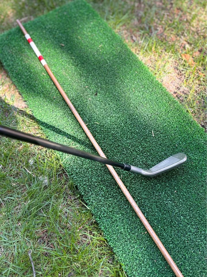 Hickory alignment stick shown next to a golf iron for scale