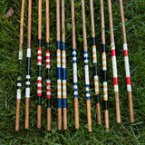 Collection of handmade hickory alignment sticks showing custom painted colour combinations