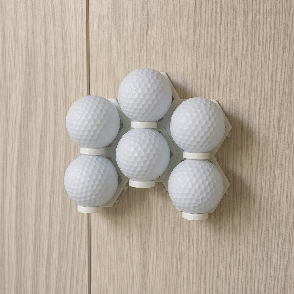 Six plain white golf balls arranged in installed modular wall display mounts