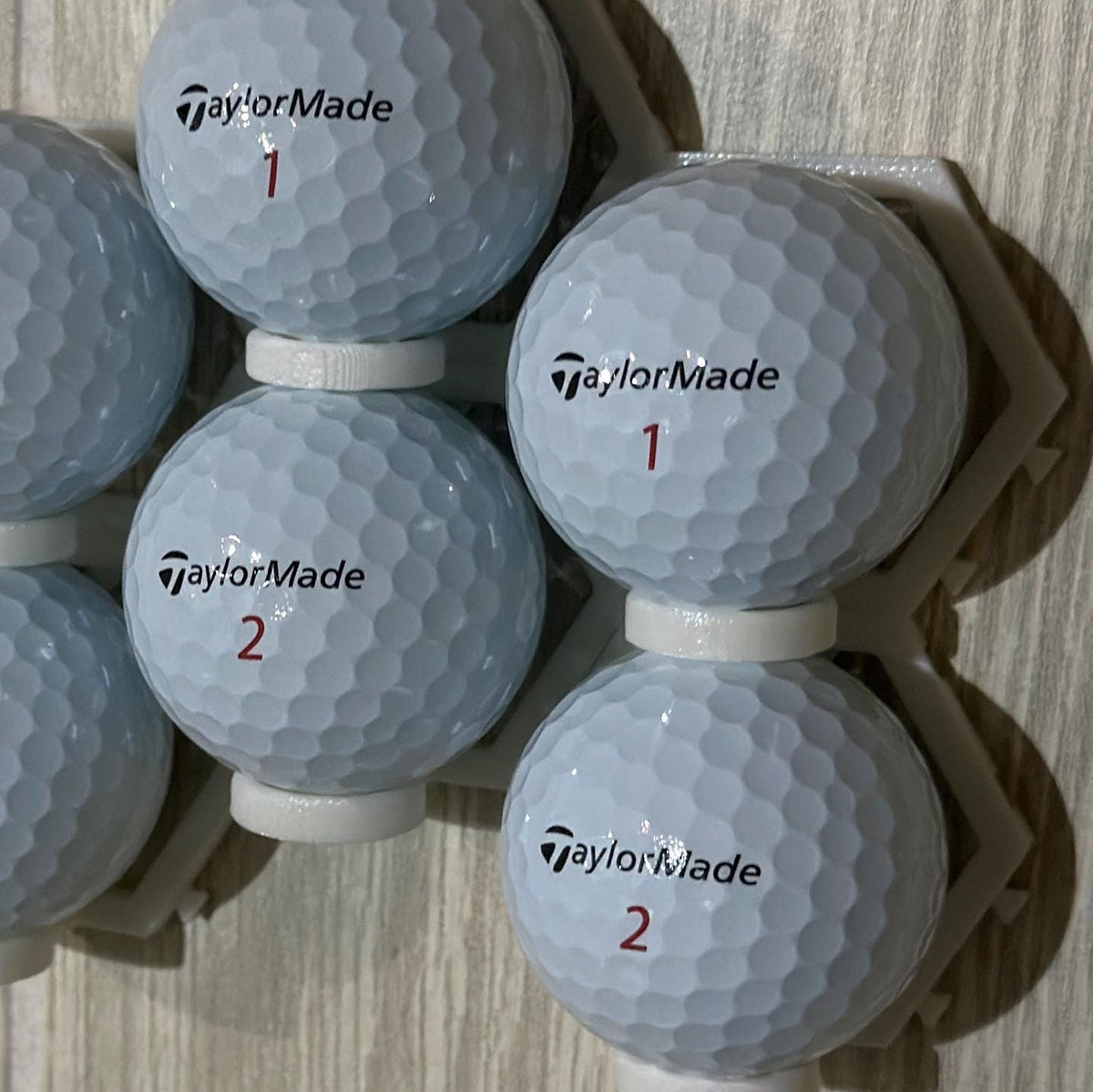 Six golf balls in connected wall mounts, close view