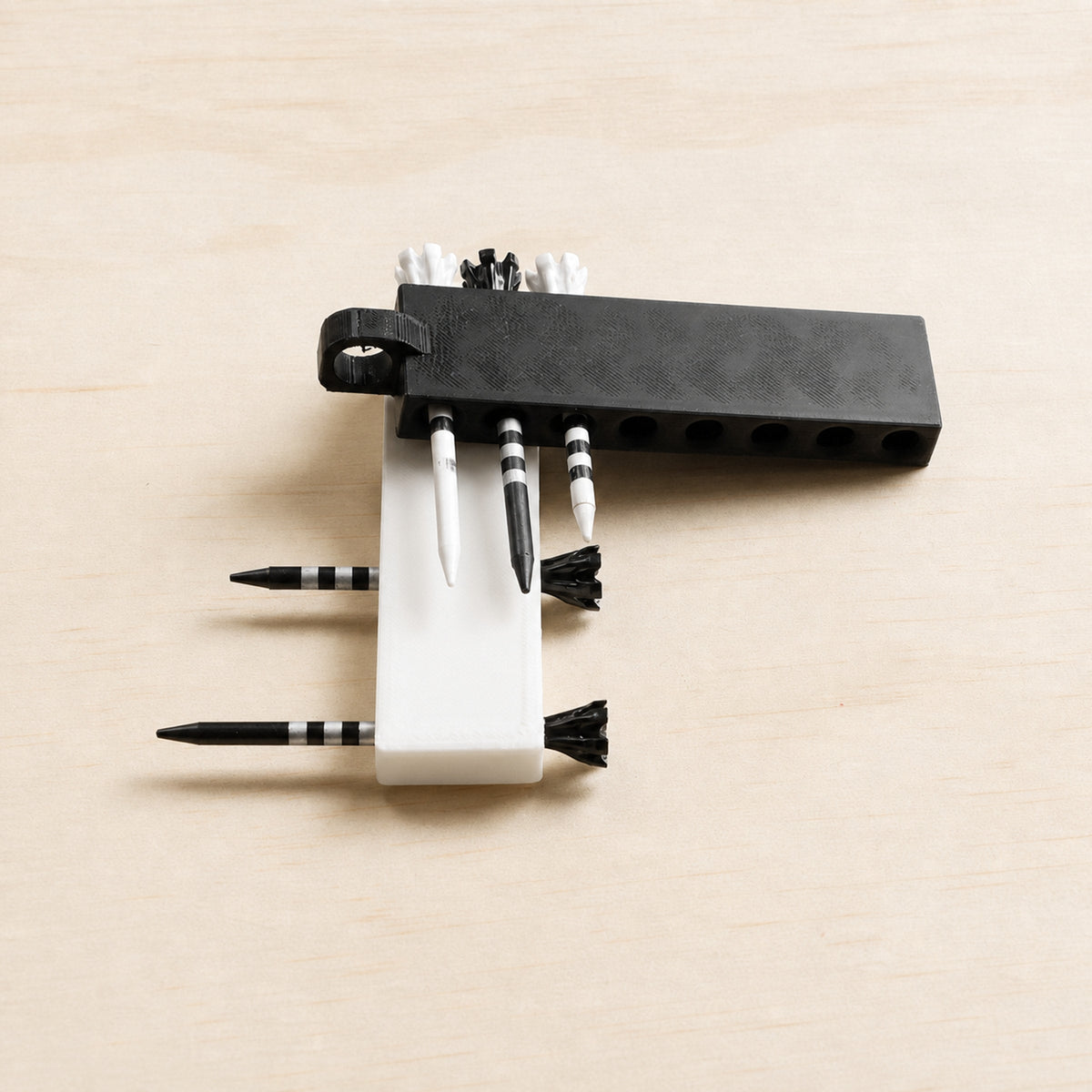 Black and white golf tee holders shown from above