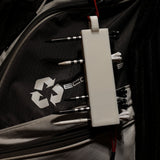 White golf tee holder loaded with tees and hanging from a golf bag