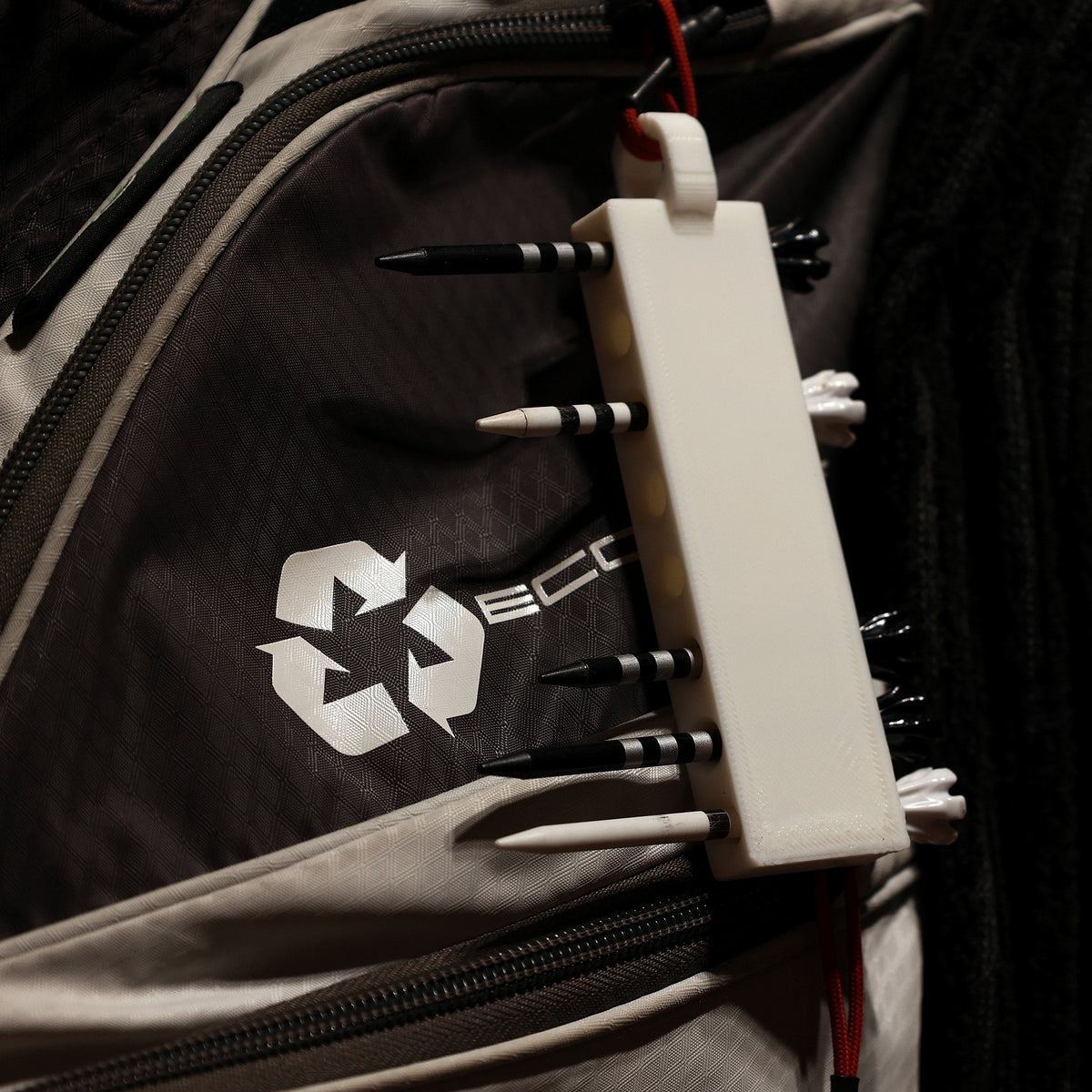 White golf tee holder in use on a golf bag