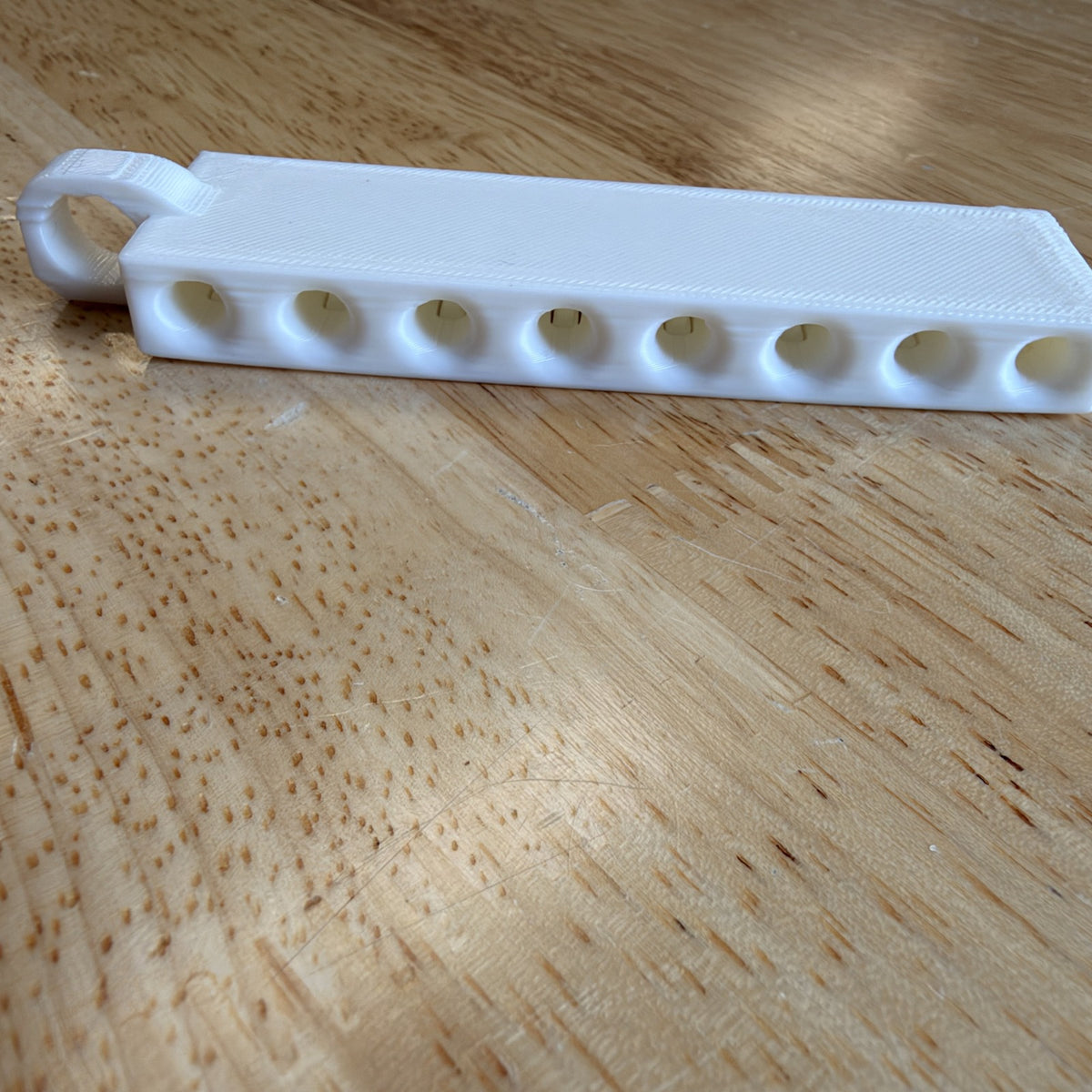 Golf tee holder showing the eight tee openings