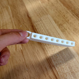 Golf tee holder held in a hand for scale