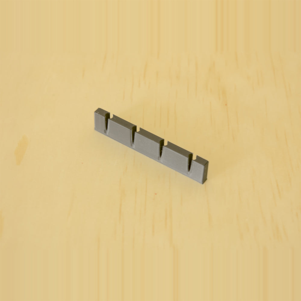 Empty black wall-mounted golf tee display showing four tee positions