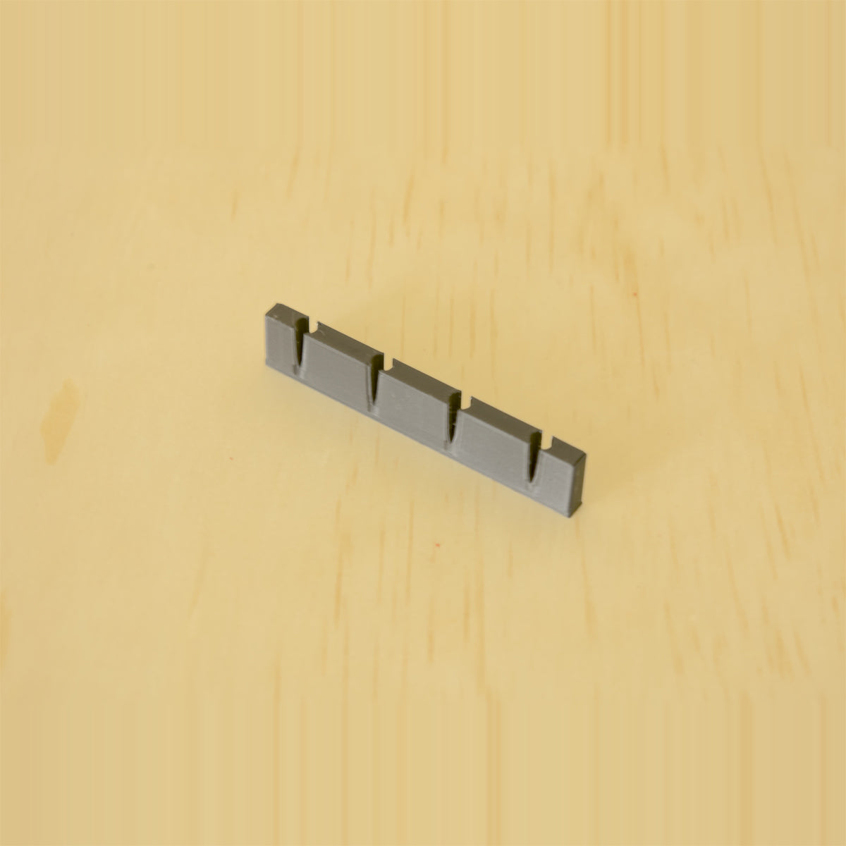 Empty black wall-mounted golf tee display showing four tee positions