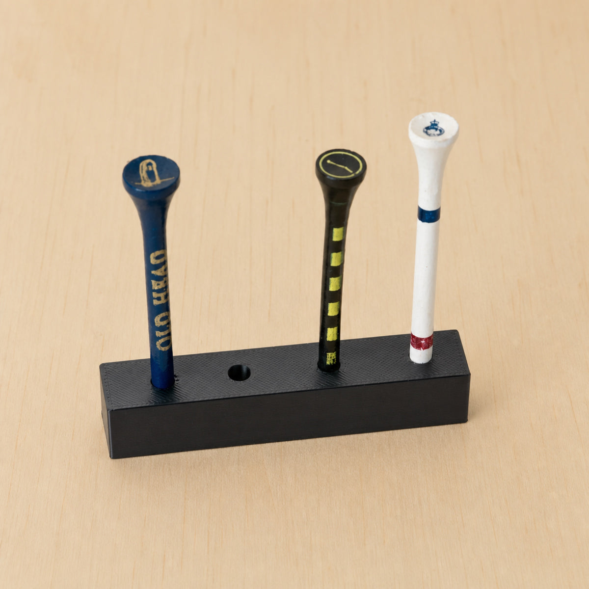 Detailed angled view of a black freestanding four-position golf tee display