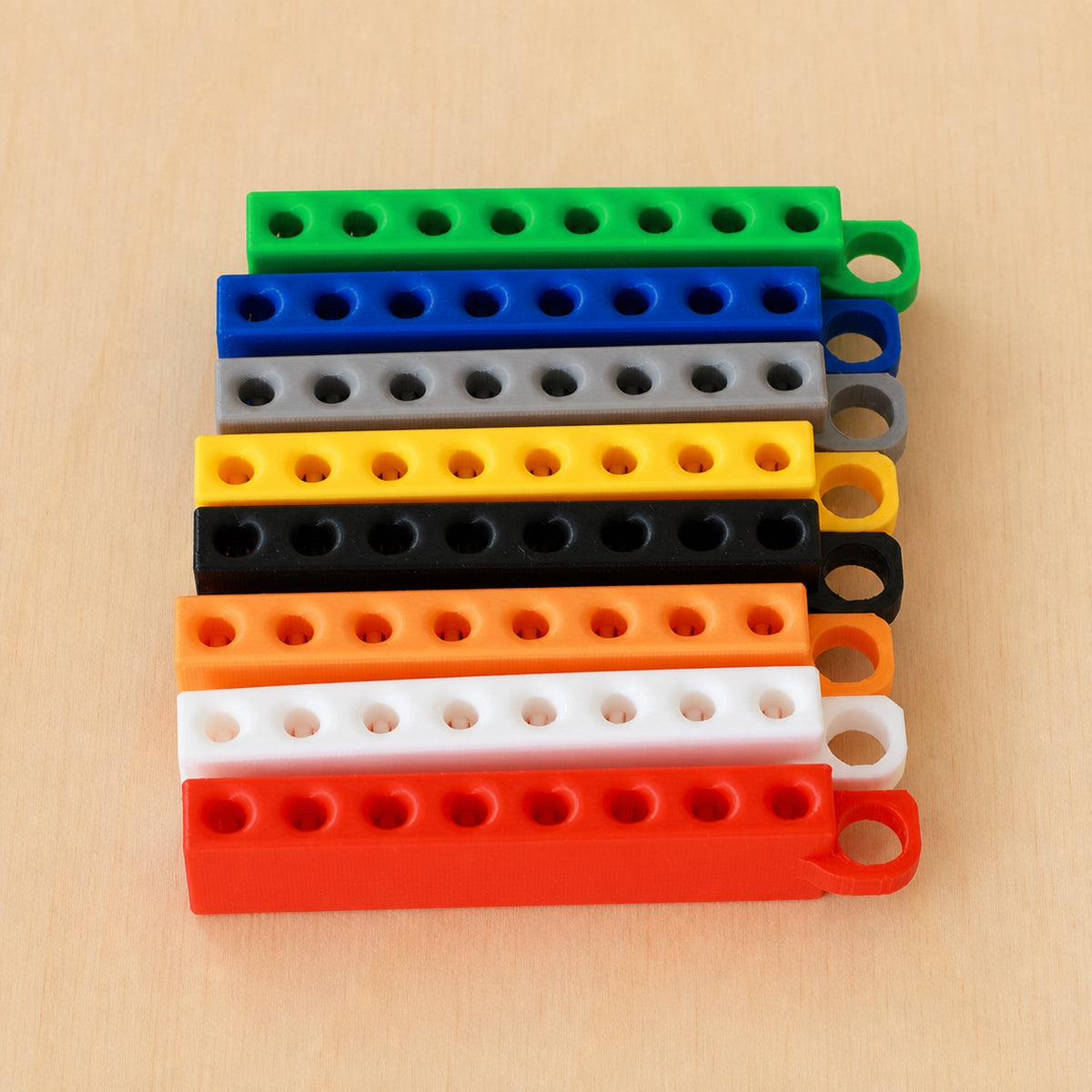 Eight Golf Tee Holders showing eight colour examples on pale wood