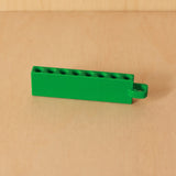 Green Golf Tee Holder with eight tee openings and hanging loop on pale wood