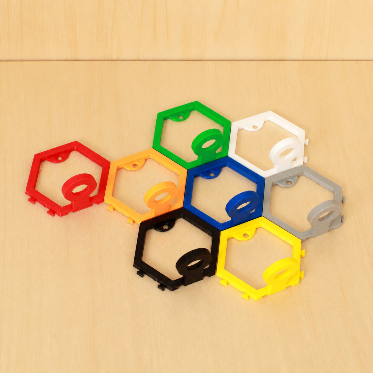 Eight modular golf ball display mounts showing eight colour examples on pale wood