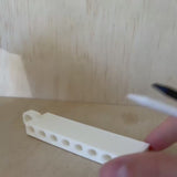 Golf Tee Holder being loaded with and emptied of eight golf tees