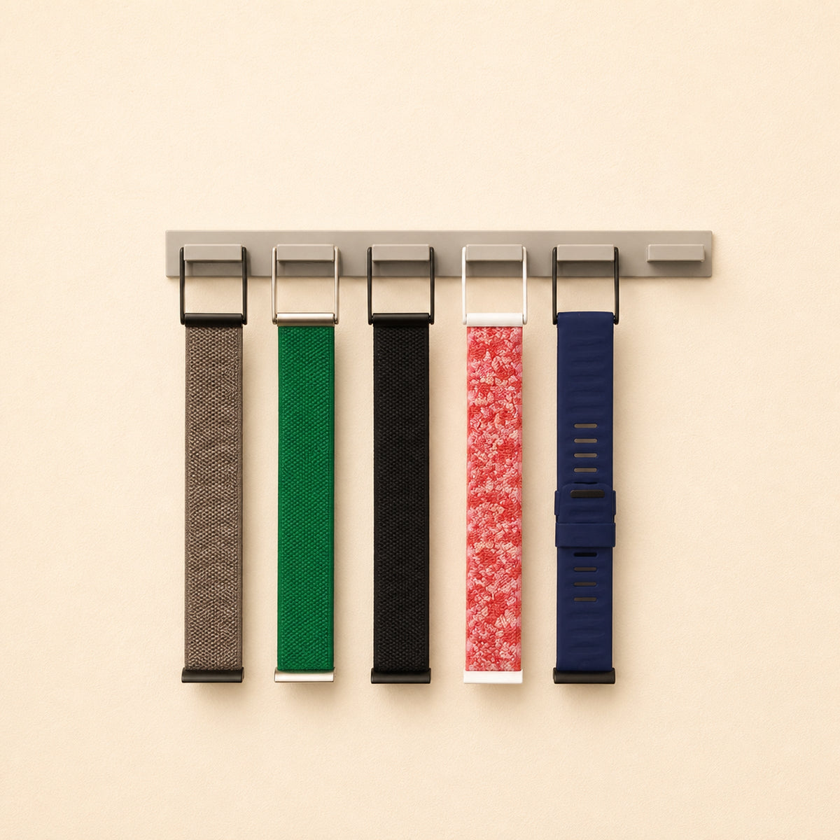 Full view of five WHOOP bands hanging from a six-position grey wall holder